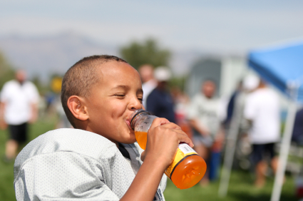 Young African-American football player drinking a sports drink