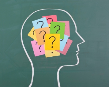Brain with question marks on post it notes