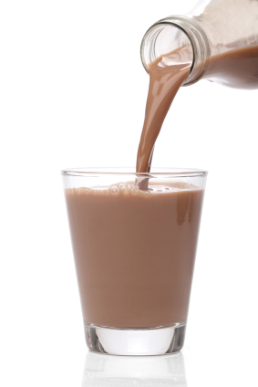 Chocolate milk being poured from bottle to glass