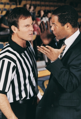 Coach arguing with basketball referee