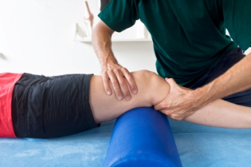 Physical therapist examining knee