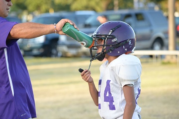 Football coach giving player water