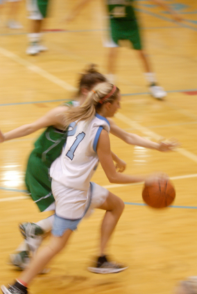 Female basketball player dribbling up court