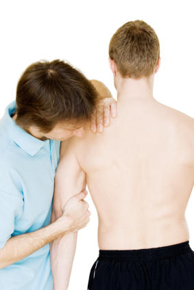 Physical therapist examining teen's shoulder