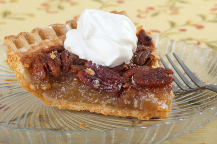 Pecan pie topped with dollop of whipped cream