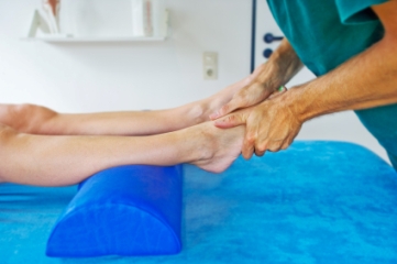 Physical therapist examining patient's legs