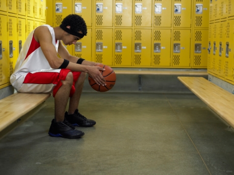 Sad basketball player in locker room