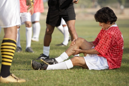 Soccer player holding injured leg