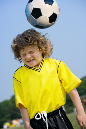 Young soccer player heading ball 