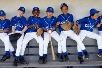 Youth baseball team in dugout having fun