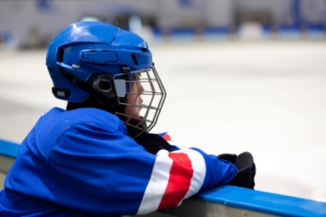 Youth hockey player watching action from bench