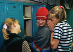 Three high school girls at locker
