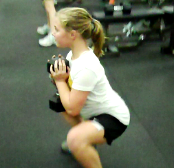 Young girl doing resistance training (squats with weights)